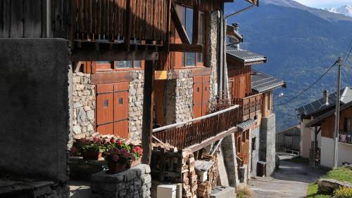 a building with a balcony and flowers on a street at alpes studio in Feissons-sur-Salins