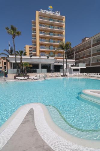 uma grande piscina em frente a um hotel em Hotel Reymar Playa em Malgrat de Mar