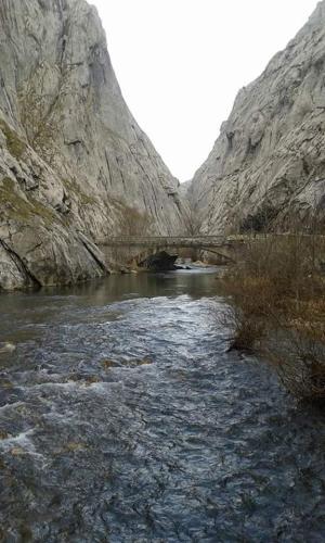 a bridge over a river in a canyon at La Loma in Boñar