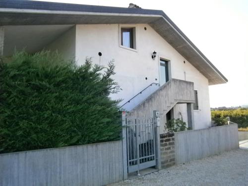 a white house with a fence and a gate at Appartamenti sapori di campagna in Pescantina