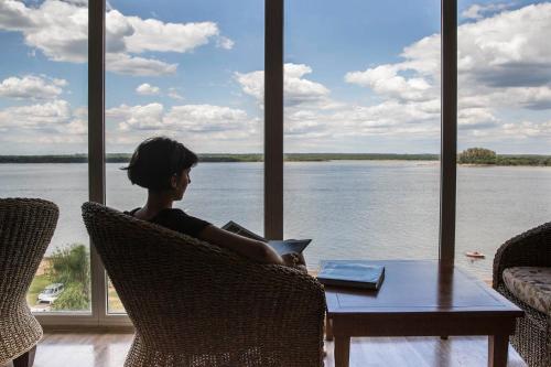 uma mulher sentada numa mesa olhando para a água em Costarenas Hotel & Spa em Colón