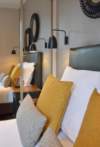 a bedroom with two beds with pillows and lamps at Hôtel Le Fer à Cheval in Trouville-sur-Mer