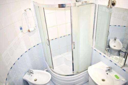 y baño con ducha, aseo y lavamanos. en Apartment on Krushelnitskoy 73 en Rivne