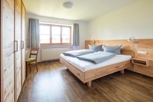 a bedroom with a large bed and a window at Haflingerhof - Oberjoch in Bad Hindelang