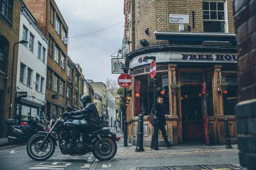 a man riding a motorcycle on a city street at The Hoxton, Shoreditch in London