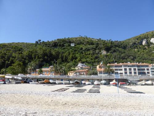 a beach with umbrellas and a bridge and a mountain at Soqquadro Art&Relax - Spotorno (SV) Sea View in Spotorno