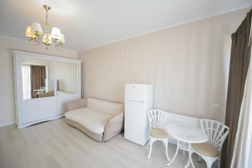 a living room with a couch and a table and a refrigerator at Complex Bavaro in Mamaia Sat/Năvodari