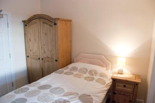 um quarto com uma cama e um armário de madeira em The Blacksmiths Arms em Penistone