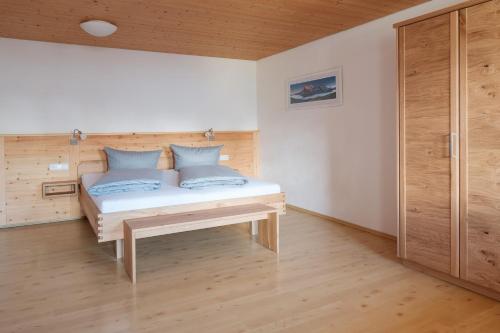 a small bed in a room with wooden walls at Haflingerhof - Oberjoch in Bad Hindelang
