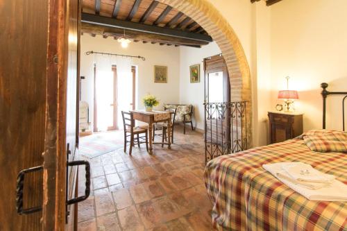 a bedroom with a bed and a table in a room at Fattoria Il Bruco in Pila