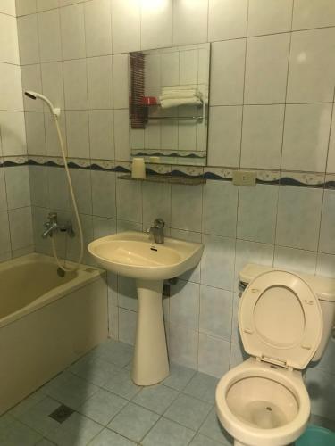 a bathroom with a toilet and a sink at Baseball Hotel in Hsinchu City