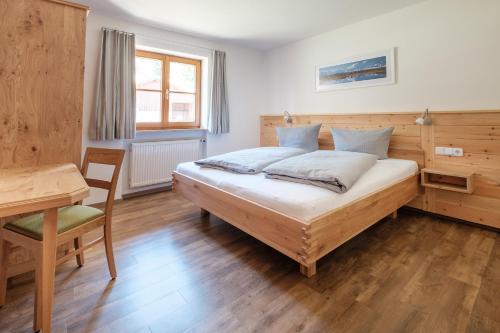 a bedroom with a bed and a table and a desk at Haflingerhof - Oberjoch in Bad Hindelang