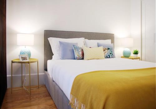 HM - Carlos Alberto Apartment 3 في بورتو: غرفة نوم مع سرير أبيض كبير مع وسائد ملونة