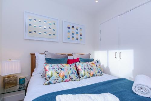 een slaapkamer met een bed met kussens erop bij Oxfordshire Living - The Alice Apartment - Oxford in Oxford