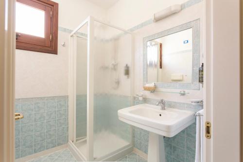 La salle de bains est pourvue d'un lavabo et d'une douche. dans l'établissement Hotel Trinacria, à San Vito Lo Capo