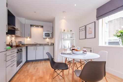 a kitchen with a table and chairs in a kitchen at Oxfordshire Living - The Alice Apartment - Oxford in Oxford