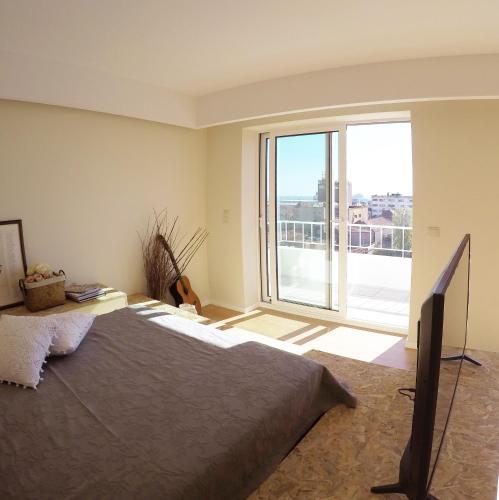 a bedroom with a large bed and a large window at Studio 177 in Matosinhos