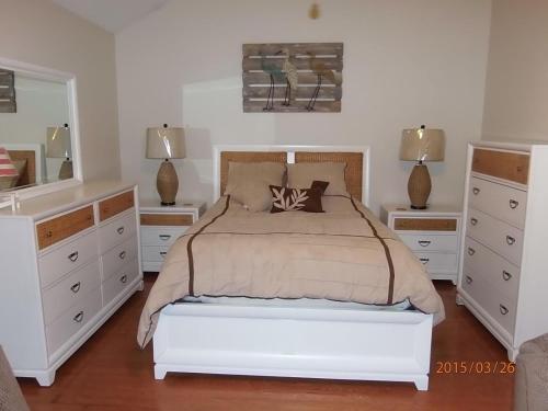 sypialnia z łóżkiem, 2 komodami i lustrem w obiekcie Biloxi Charmer w mieście Biloxi