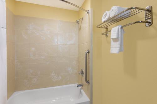 a bathroom with a shower and a toilet and a sink at Days Inn by Wyndham New Orleans Pontchartrain in New Orleans