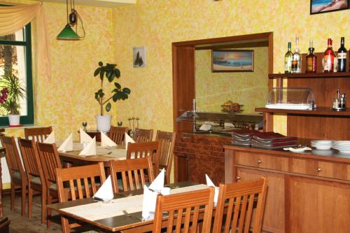 una sala da pranzo con tavoli e sedie e una cucina di Landgasthof "Wirtshaus Zur Eibe" a Jabel