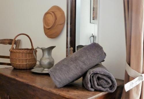 - une étagère avec une serviette, un panier et un miroir dans l'établissement Les Terrasses - Gordes, à Gordes