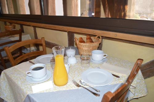 a table with plates and a bottle of orange juice at Le Clos Margot in Vertus