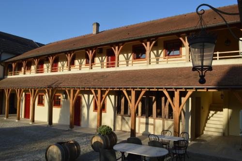 a building with tables and chairs in front of it at Le Clos Margot in Vertus