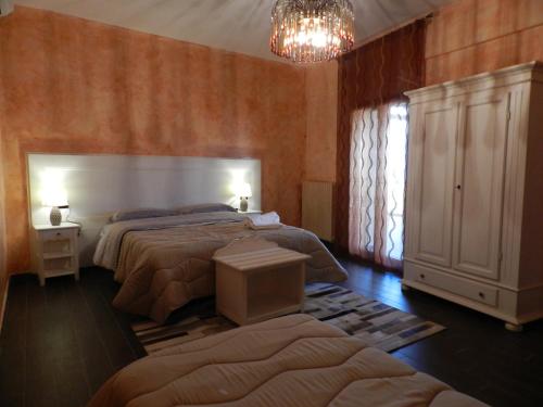 恩納的住宿－Enna Cerere，一间卧室配有两张床和吊灯。