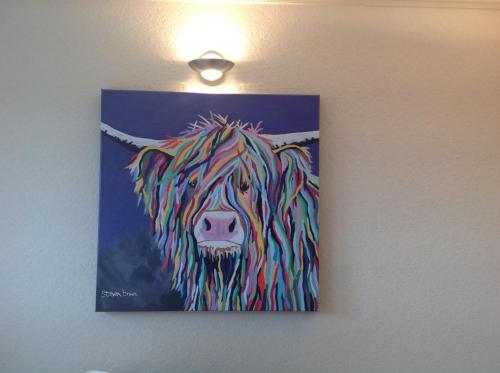 a painting of a cow hanging on a wall at East Hillerton House in Crediton