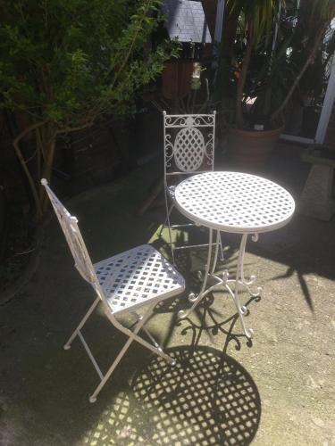 two chairs and a table and a table and chairs at Elmdon Lodge in Birmingham
