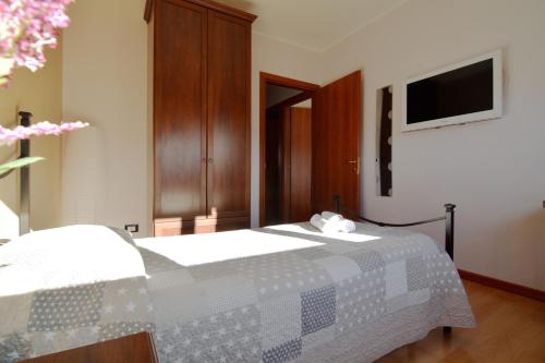 a bedroom with a bed and a tv on the wall at B&B Culla Dell'Aquila in LʼAquila