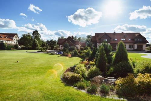 a yard with a house and a lawn with bushes at Apartamenty U BARBARY in Ełk