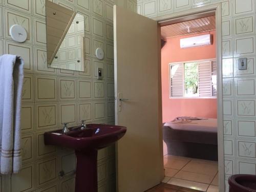 a bathroom with a sink and a room with a bed at Hotel Comodoro De Bagé in Bagé