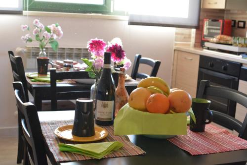 a table with a bowl of fruit and a bottle of wine at B&B Culla Dell'Aquila in LʼAquila