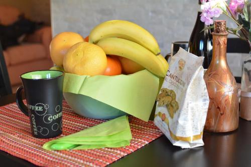 a bowl of fruit on a table with a cup at B&B Culla Dell'Aquila in LʼAquila