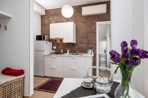 a kitchen with purple tulips in a vase on a table at Dreamsrome Lux in Rome