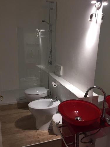 a bathroom with a toilet and a red sink at AL183 in Cagliari