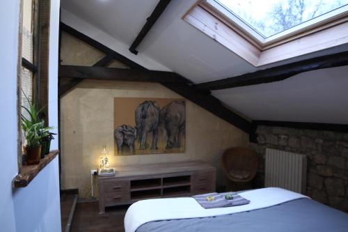 sypialnia z łóżkiem i dwoma słoniami na ścianie w obiekcie Le moulin scalagrand w mieście Mazières