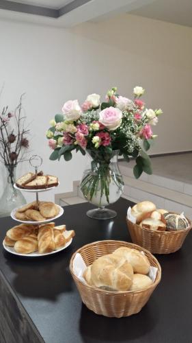 a table with baskets of bread and a vase of flowers at Boutique-Hotel Kronenstuben in Ludwigsburg