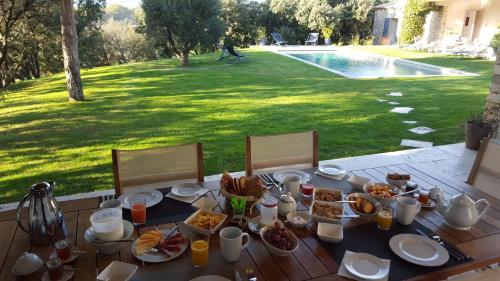 a table with food on it with a view of a yard at Les Terrasses - Gordes in Gordes