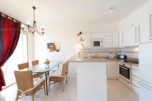 une cuisine et une salle à manger avec une table et des chaises dans l'établissement Blanc cel, à Cannes
