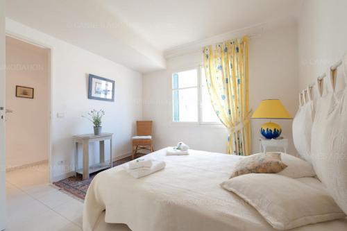 une chambre blanche avec un grand lit et une fenêtre dans l'établissement Blanc cel, à Cannes