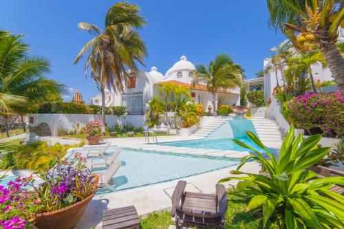 a villa with a swimming pool and palm trees at Villas Fasol Huatulco in Santa Cruz Huatulco