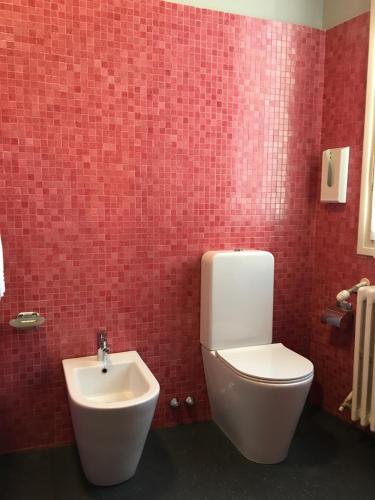 a bathroom with a white toilet and a sink at B&B L'Affresco in Mantova