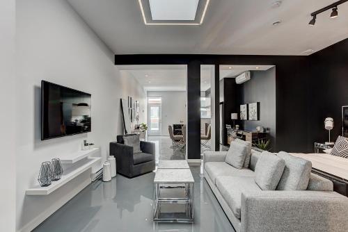 a living room with a couch and a tv at Les Lofts du Centre by Simplissimmo in Montréal