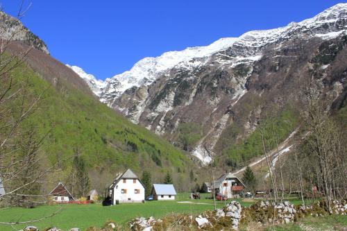 a group of houses in a valley with a mountain at Apartma Ana in Bavšica