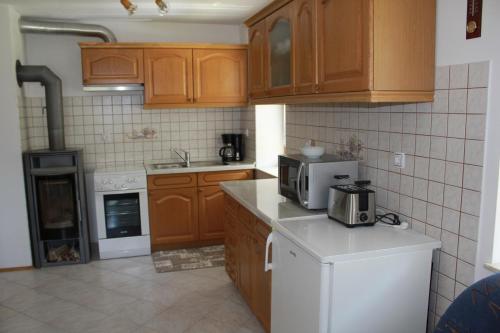 a kitchen with wooden cabinets and a white appliance at Apartma Ana in Bavšica