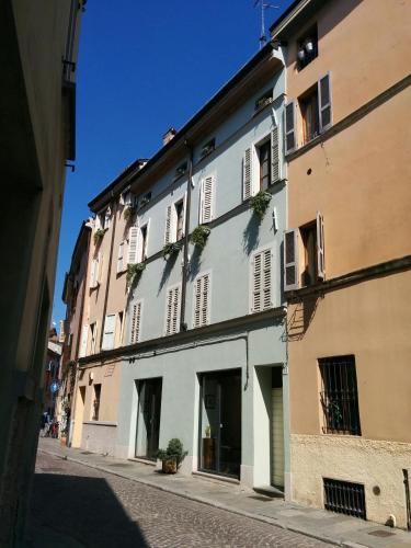 - un bâtiment blanc avec des fenêtres donnant sur une rue dans l'établissement Honey House Parma, à Parme
