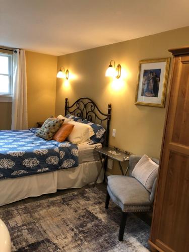 a bedroom with a bed and a chair at Robert Porter House Inn in Victoria