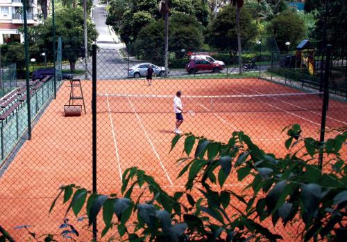 two people playing tennis on a tennis court at Estudio Itaipava in Itaipava